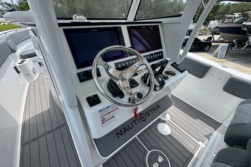 Slide: The Image of 2026 NauticStar 332 Offshore boat helm with dual screens and steering wheel. - 37