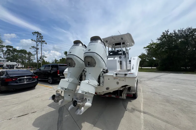 Slide: The Image of 2026 NauticStar 332 Offshore boat with dual outboard engines in a parking lot. - 15