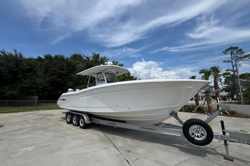 Slide: The Image of 2026 NauticStar 332 Offshore boat on trailer under a clear blue sky. - 9