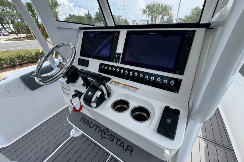 Slide: The Image of 2026 NauticStar 332 Offshore boat dashboard with dual screens and steering wheel. - 40