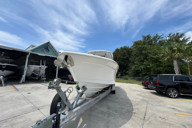 Slide: The Image of 2026 NauticStar 332 Offshore boat on trailer, parked outdoors near a garage. - 6