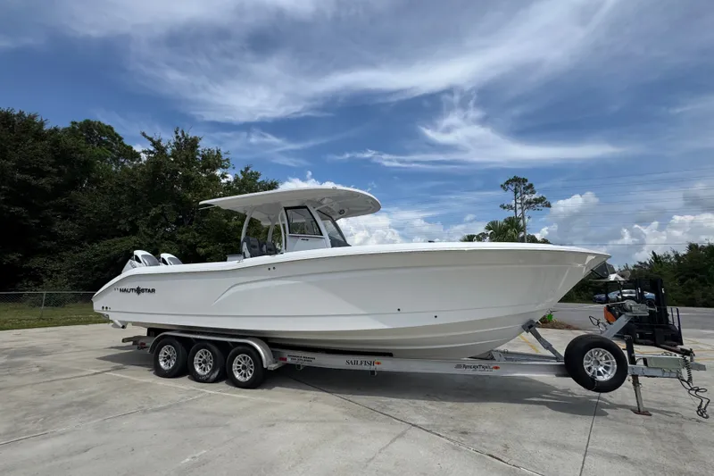Slide: The Image of 2026 NauticStar 332 Offshore boat on trailer under a clear blue sky. - 10