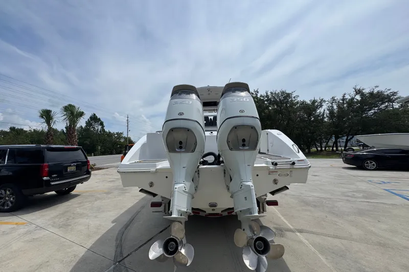 Slide: The Image of 2026 NauticStar 332 Offshore boat with dual outboard engines in a parking lot. - 16