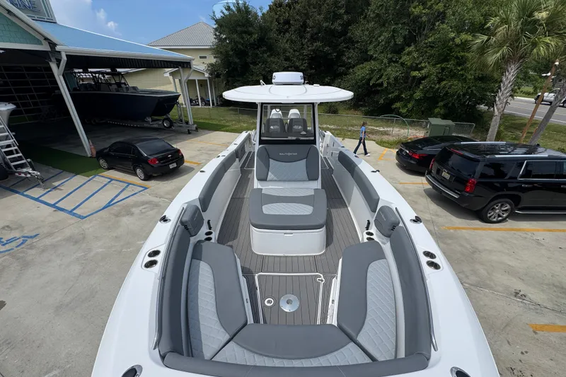 Slide: The Image of 2026 NauticStar 332 Offshore boat with spacious seating, docked in a parking area. - 24