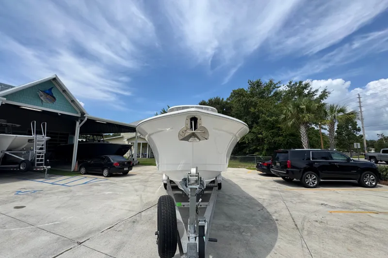Slide: The Image of 2026 NauticStar 332 Offshore boat on trailer, parked outdoors under a clear blue sky. - 7
