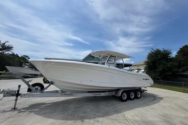 Slide: The Image of 2026 NauticStar 332 Offshore boat on trailer under clear sky. - 3