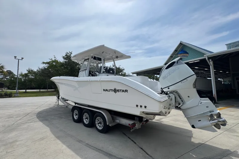 Slide: The Image of 2026 NauticStar 332 Offshore boat on trailer, featuring dual outboard engines. - 19
