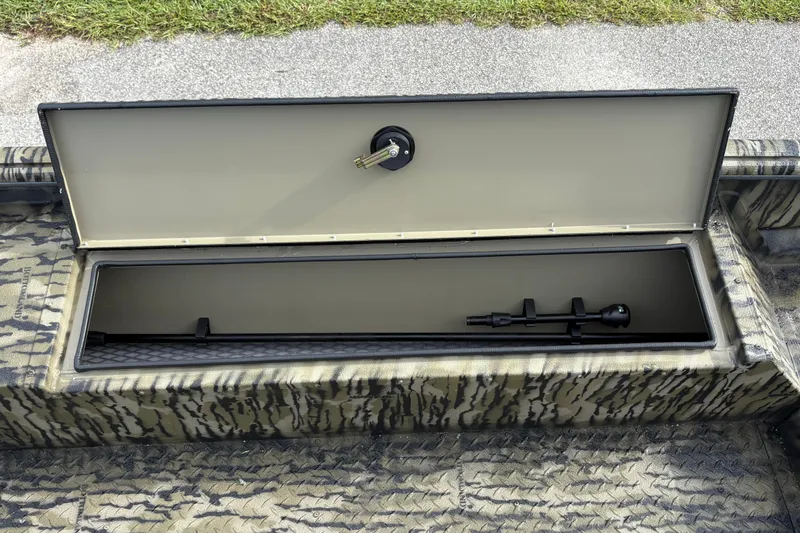 Slide: The Image of Open storage compartment in 2027 SeaArk DXS 1652 DKLD boat, featuring camouflage design. - 11