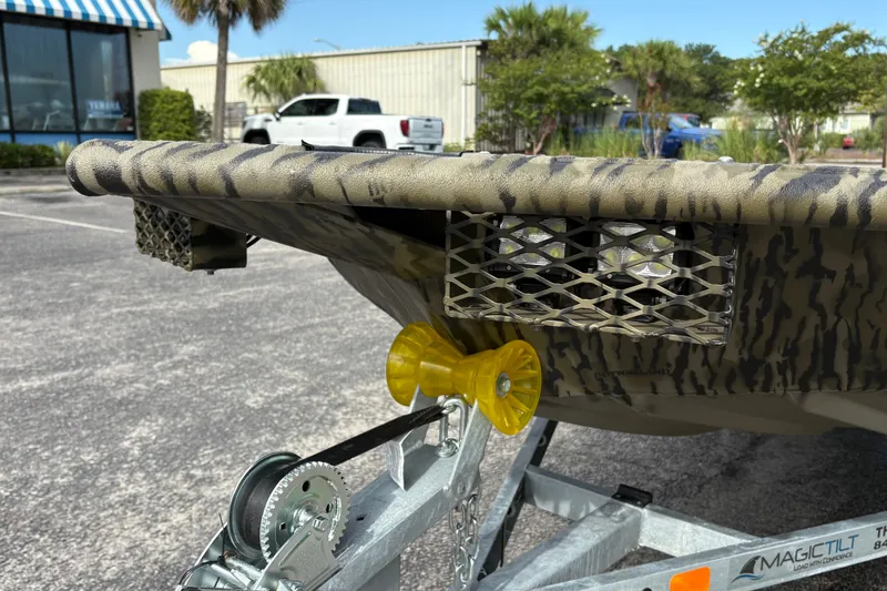 Slide: The Image of SeaArk DXS 1652 DKLD boat on trailer, showcasing camouflage design and metal mesh details. - 6
