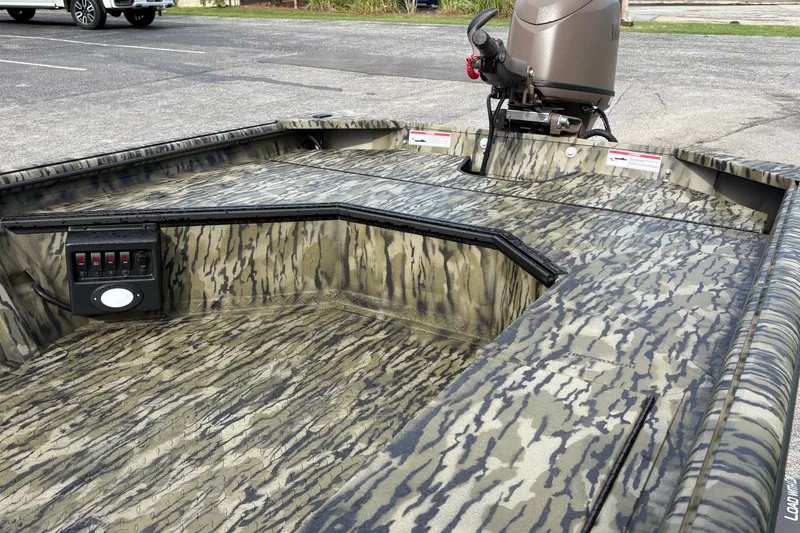 Slide: The Image of 2027 SeaArk DXS 1652 DKLD boat with camouflage design and motor in parking lot. - 10