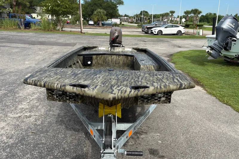 Slide: The Image of 2027 SeaArk DXS 1652 DKLD boat on trailer, featuring camouflage design and outboard motor. - 5