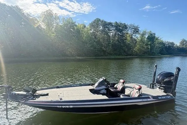Slide: The Image of 2026 Skeeter ZXE20 boat on a serene lake with lush green trees. - 13
