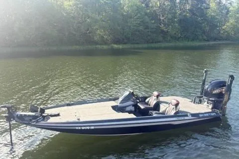Slide: The Image of 2026 Skeeter ZXE20 boat on a calm lake with lush green surroundings. - 16