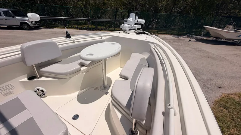 Slide: The Image of The image shows the deck of a 2024 Mako 214CC boat with seating and a table. - 17