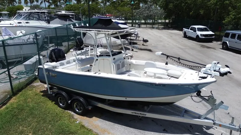 Slide: The Image of 2024 Mako 214CC on a trailer, parked in a marina area, surrounded by other boats. - 19