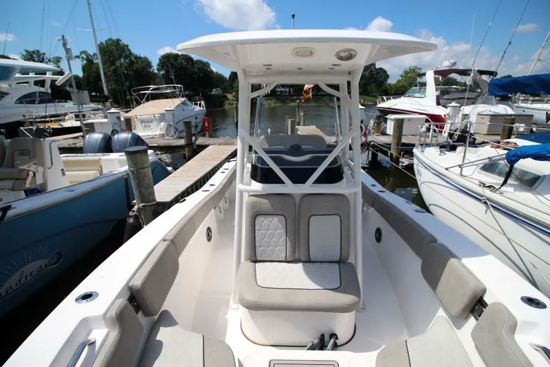 Slide: The Image of 2022 Sea Fox 228 Commander boat docked at a marina, surrounded by other vessels. - 11
