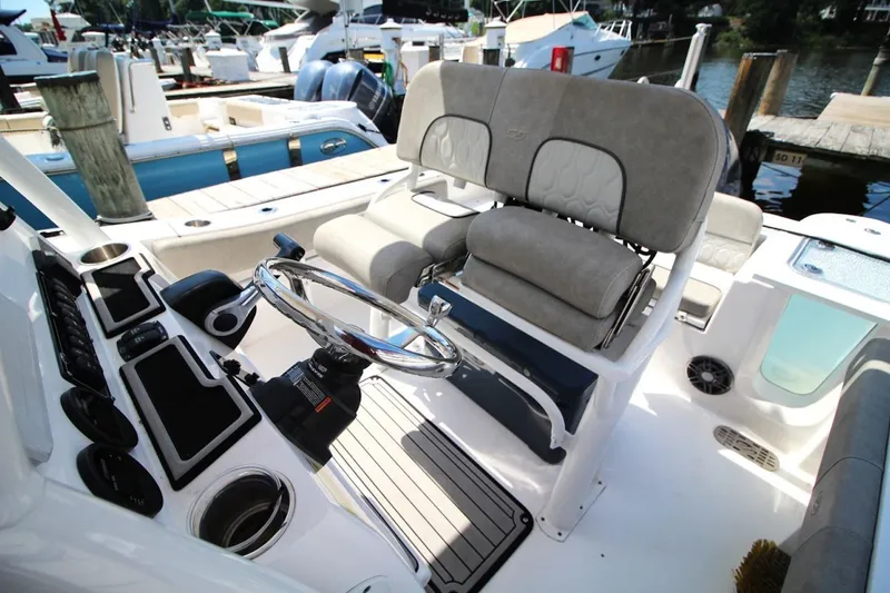 Slide: The Image of 2022 Sea Fox 228 Commander boat interior with steering wheel and cushioned seating. - 12