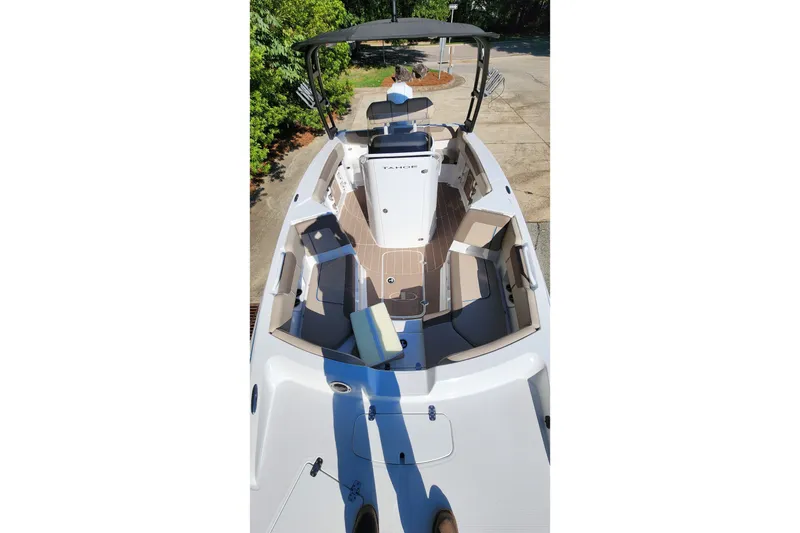 Slide: The Image of 2026 Tahoe 2150 CC boat interior with seating and console, docked outdoors. - 5