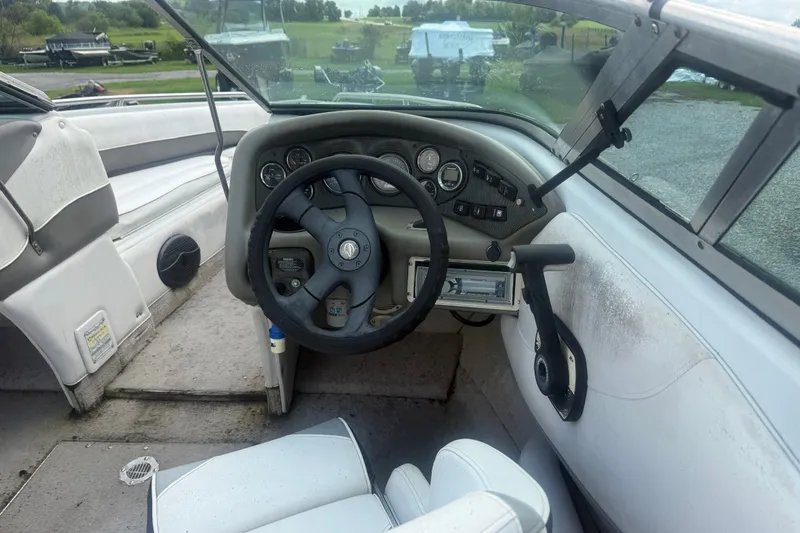 Slide: The Image of Interior of a 2000 Crownline 202 BR boat showing steering wheel and dashboard controls. - 18