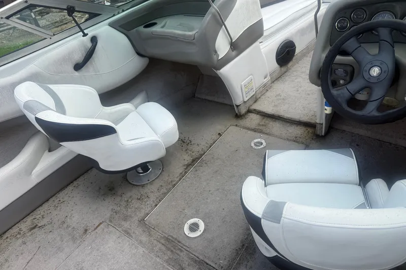 Slide: The Image of Interior of a 2000 Crownline 202 BR boat with white seating and steering wheel. - 21