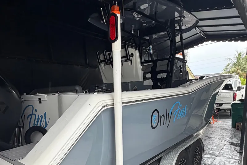 Slide: The Image of 2020 Tidewater 280 CC Adventure boat in garage, featuring "Only Fins" logo on the side. - 3
