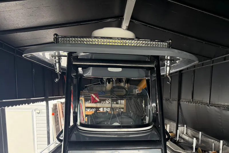 Slide: The Image of 2020 Tidewater 280 CC Adventure boat under a covered storage area. - 12