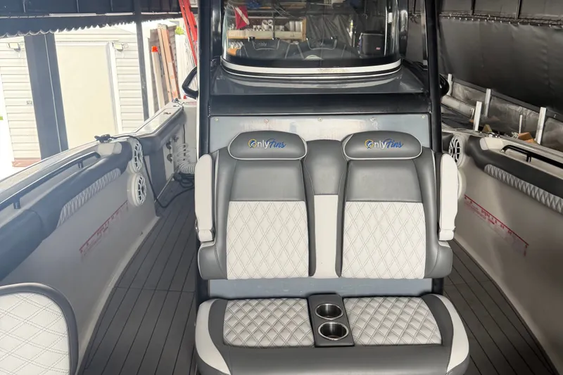 Slide: The Image of 2020 Tidewater 280 CC Adventure boat interior with cushioned seating and cup holders. - 13