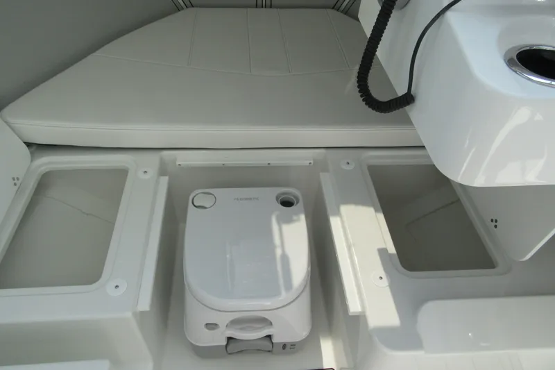 Slide: The Image of Interior of 2027 Parker 247 Explorer boat featuring storage compartments and a portable toilet. - 18