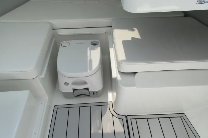 Slide: The Image of Interior of 2027 Parker 247 Explorer boat with compact toilet and cushioned seating. - 19
