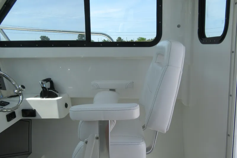 Slide: The Image of Interior of 2027 Parker 247 Explorer boat with white seating and steering controls. - 14