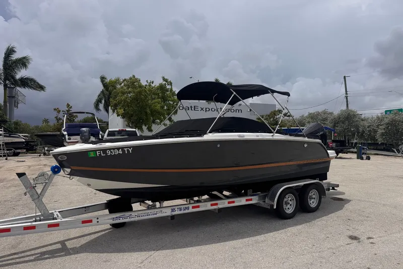 Slide: The Image of 2023 Four Winns H2 OB boat on trailer, parked outdoors under cloudy sky. - 4