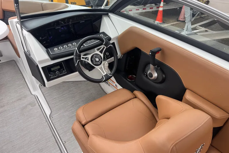 Slide: The Image of 2023 Four Winns H2 OB boat cockpit with tan seating and modern controls. - 9