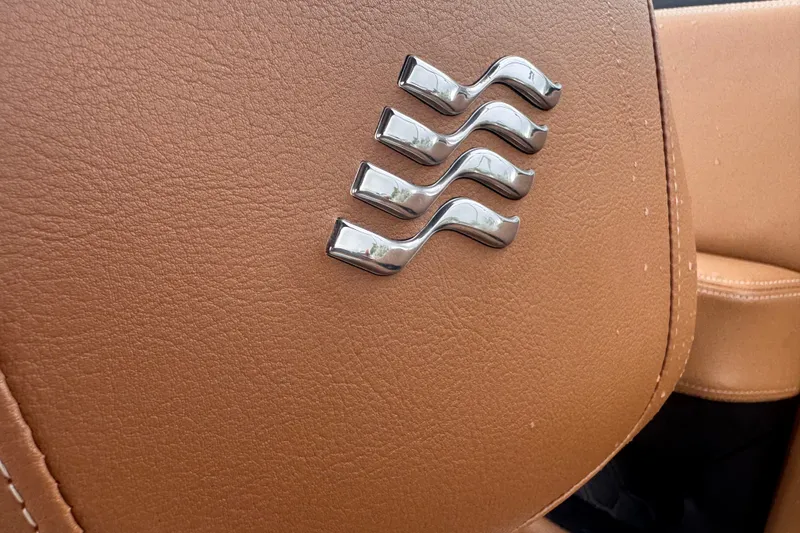 Slide: The Image of Close-up of 2023 Four Winns H2 OB leather interior with chrome wave emblem. - 15
