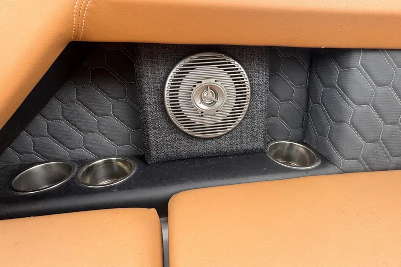 Slide: The Image of 2023 Four Winns H2 OB interior with speaker, cup holders, and hexagonal upholstery design. - 13