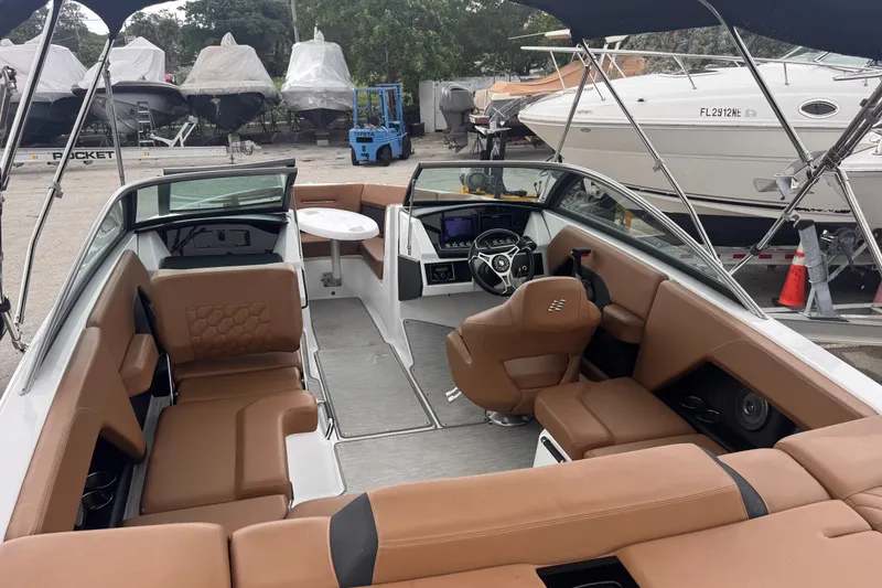 Slide: The Image of 2023 Four Winns H2 OB boat interior with tan seating and modern dashboard. - 8