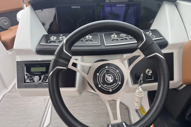 Slide: The Image of 2023 Four Winns H2 OB boat dashboard with steering wheel and control panel. - 10
