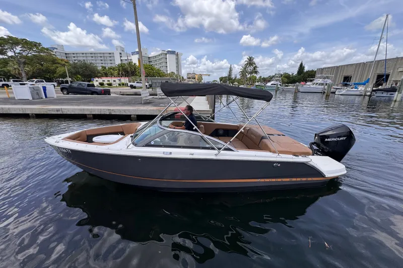 Slide: The Image of 2023 Four Winns H2 OB boat docked in a marina under a partly cloudy sky. - 2