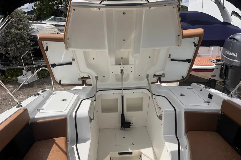 Slide: The Image of 2023 Four Winns H2 OB boat interior with open storage compartment and seating. - 17