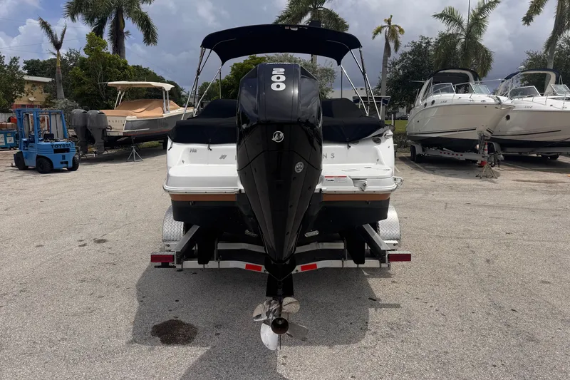 Slide: The Image of 2023 Four Winns H2 OB boat with outboard motor on a trailer in a marina. - 5