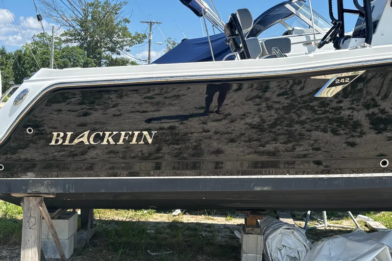 Slide: The Image of 2020 Blackfin 242 CC boat on stands, showcasing sleek black hull design. - 35