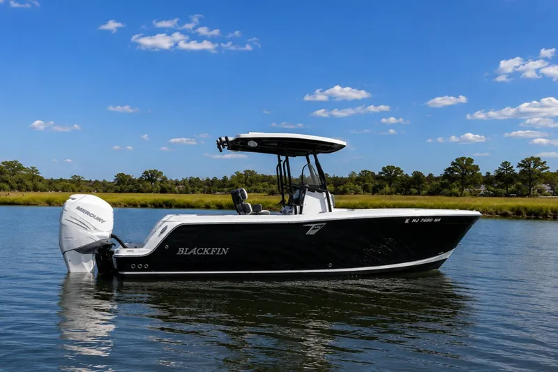 The Image of 2020 Blackfin 242 CC boat on calm water under a clear blue sky. - 0