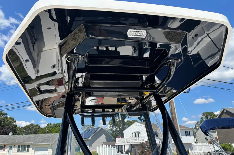 Slide: The Image of 2020 Blackfin 242 CC boat's sleek T-top design against a clear blue sky. - 19