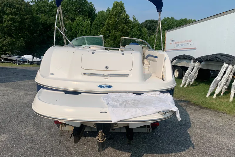 Slide: The Image of 2003 Chaparral Sunesta 236 boat rear view, parked outdoors with trees in background. - 2