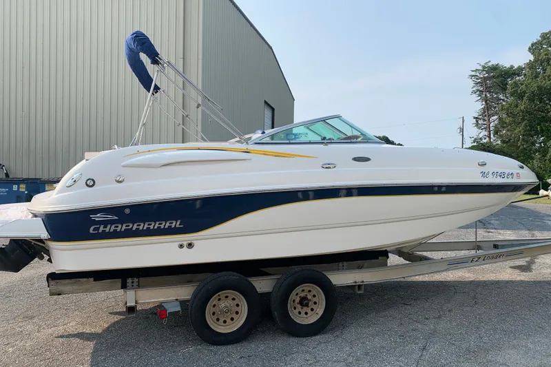 Slide: The Image of 2003 Chaparral Sunesta 236 boat on trailer, parked outdoors near a large building. - 1
