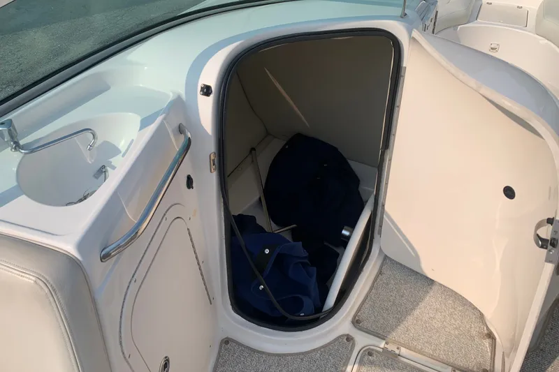 Slide: The Image of 2003 Chaparral Sunesta 236 boat interior with open storage compartment and sink. - 7
