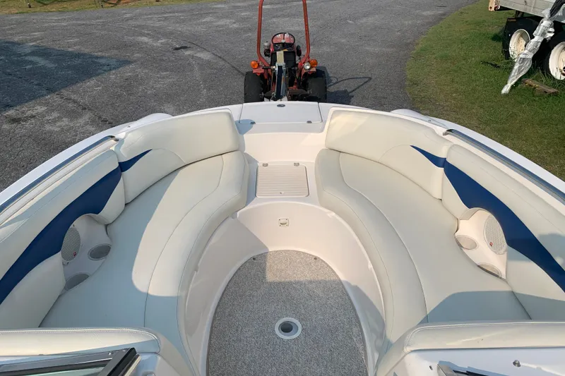 Slide: The Image of 2003 Chaparral Sunesta 236 boat interior with white and blue seating, parked on pavement. - 5
