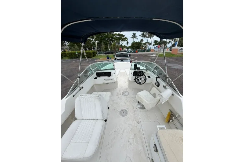 Slide: The Image of 1998 Boston Whaler 20 Ventura Bowrider with spacious seating and canopy, parked outdoors. - 12