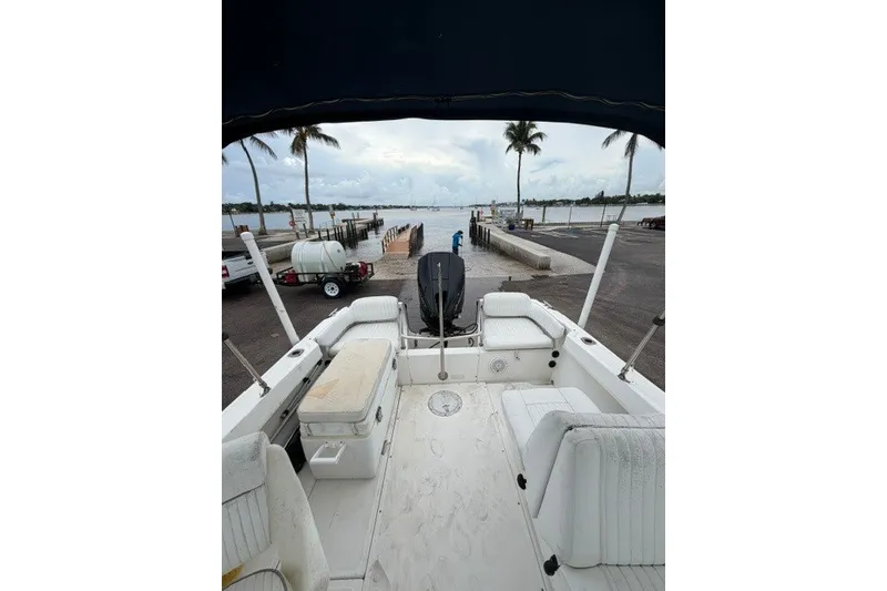 Slide: The Image of 1998 Boston Whaler 20 Ventura Bowrider at dock, overlooking serene waterfront and palm trees. - 13