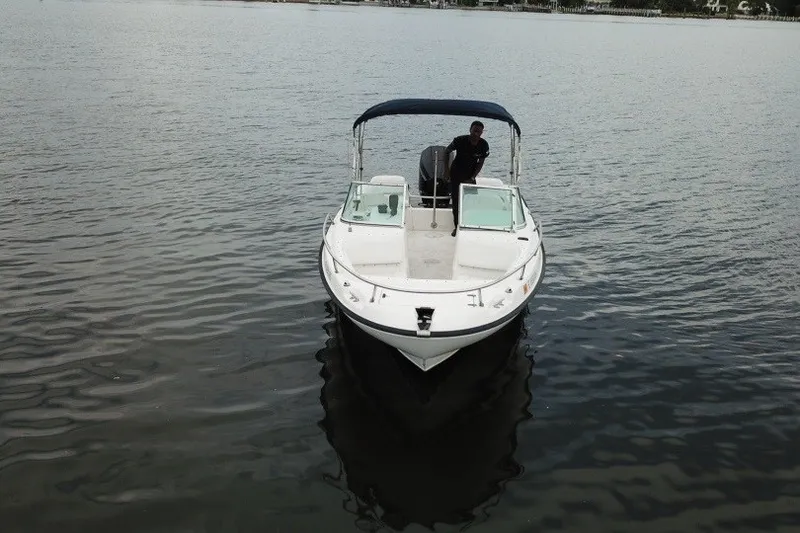 Slide: The Image of 1998 Boston Whaler 20 Ventura Bowrider on calm water, featuring a canopy and spacious deck. - 2