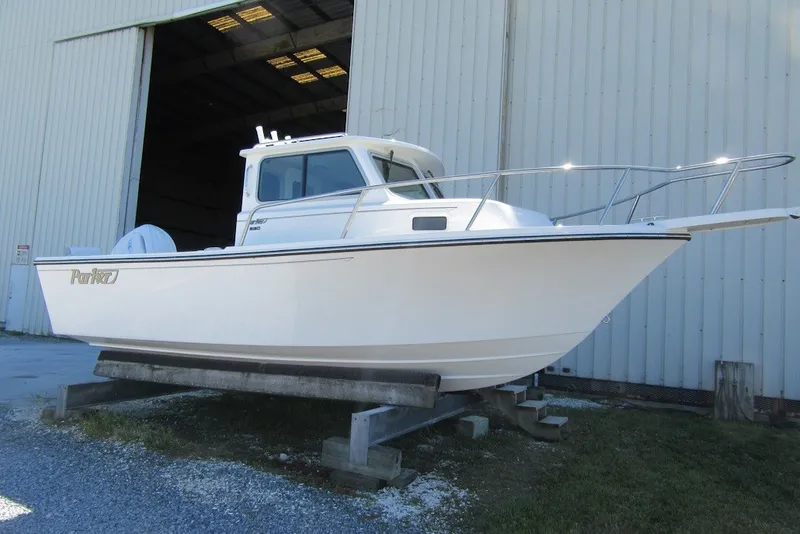 The Image of 2027 Parker 217 Explorer boat on display outside a large warehouse. - 1